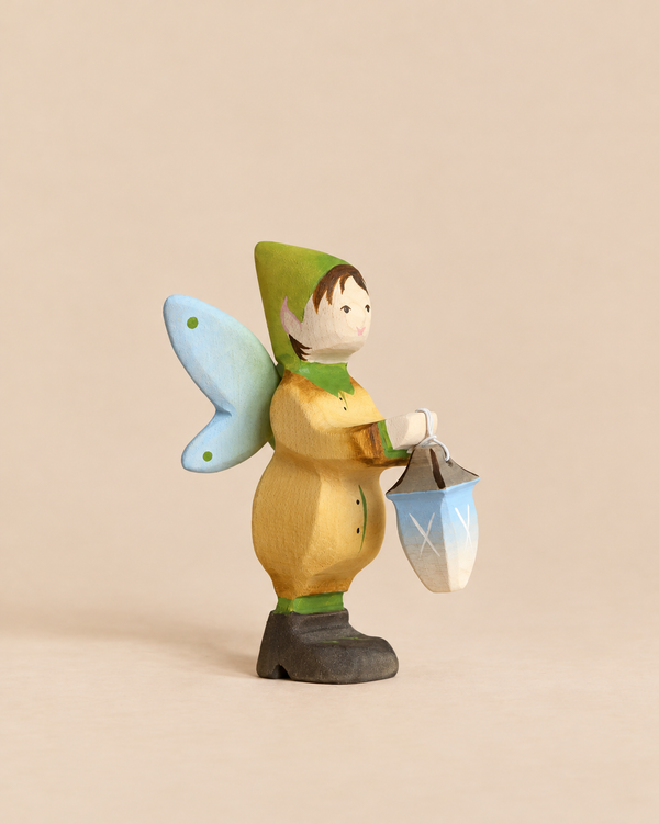 Bumbu Handmade Wooden Winged Elf with Lamp Set, a hand-carved figure with blue wings, a green cap, and a small hanging lantern.