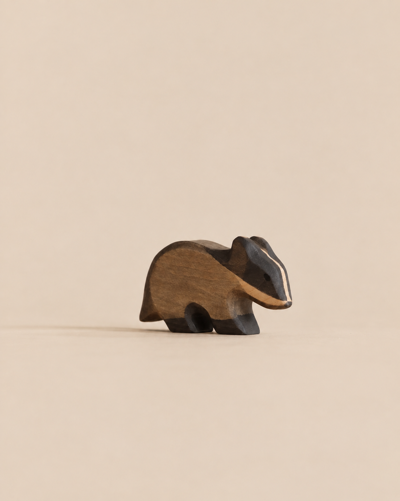 A small, handmade wooden badger figurine from the Handmade Holzwald Woodland Animals Set.