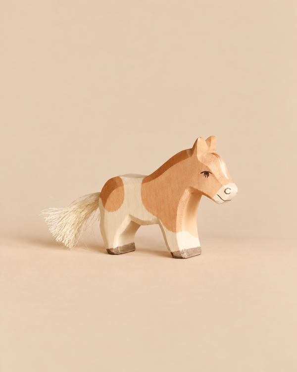 Hand-painted Ostheimer Horse - Shetland Pony Colt figurine, tan and white with a brush tail.