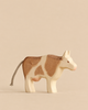 Handmade Holzwald Farm Animals Set wooden toy cow with brown patches and a rope tail.