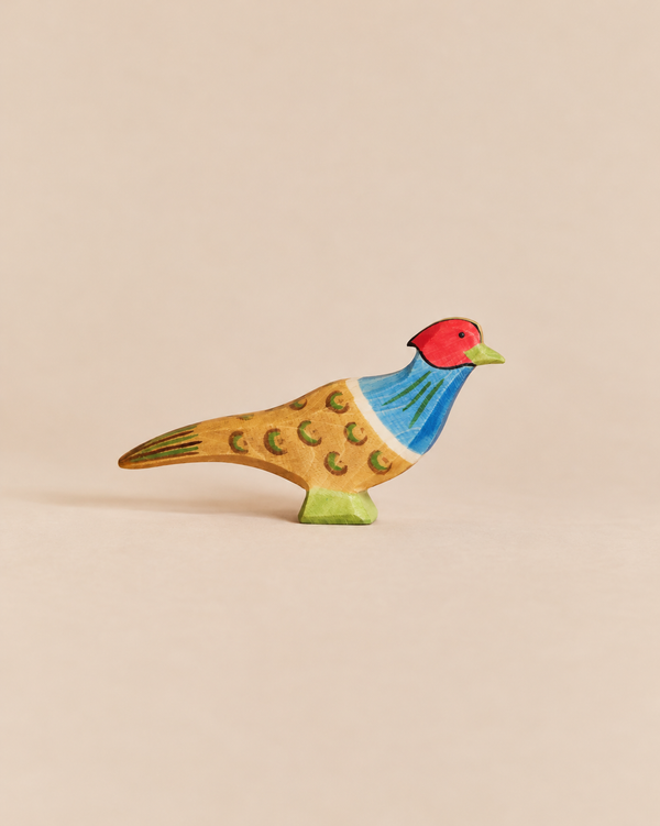 Ostheimer Pheasant handcrafted wooden figurine with a red head, blue chest, and patterned brown body.