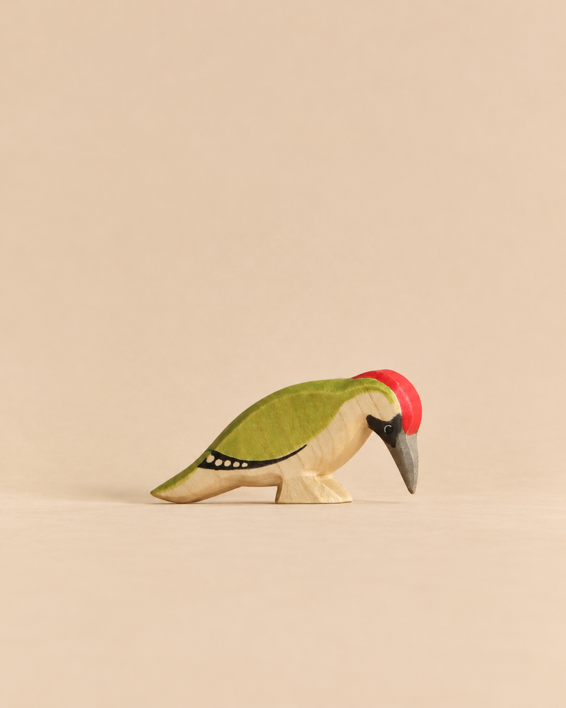 Handmade Holzwald Bird - Woodpecker figurine for imaginative play, featuring a green back, red crest, and dark grey beak.