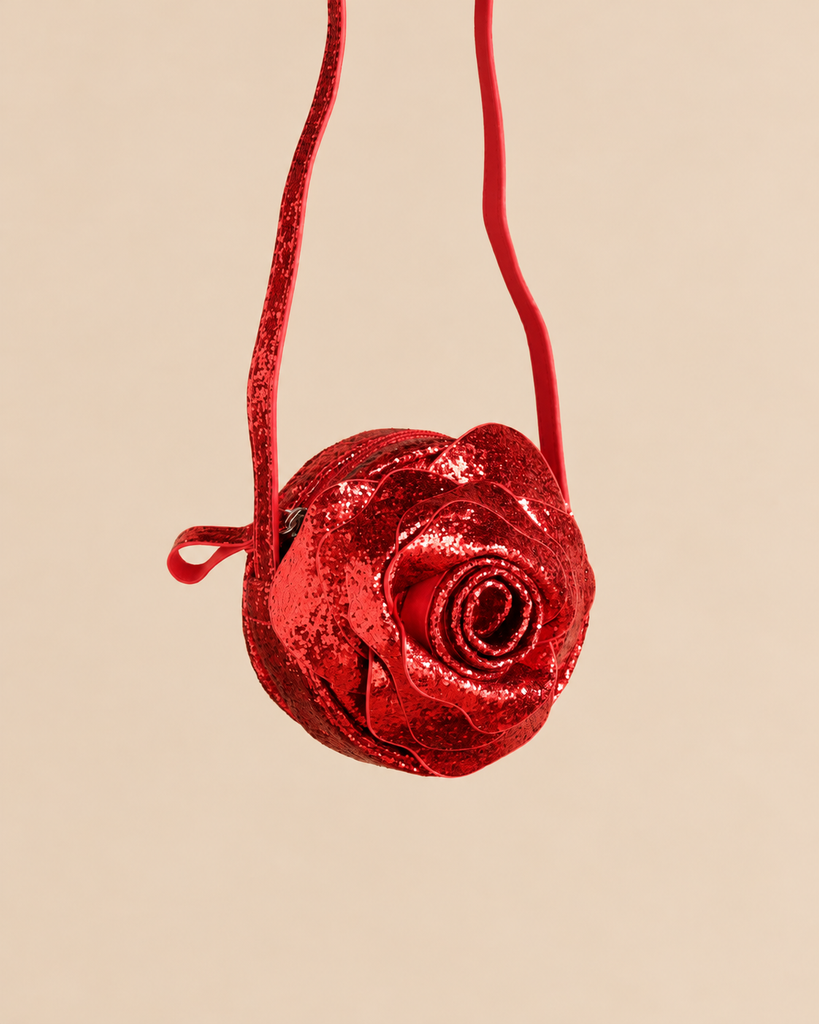Konges Sloejd Rose Shoulder Bag, a round, red, glittery bag with a slim shoulder strap and zipper closure.