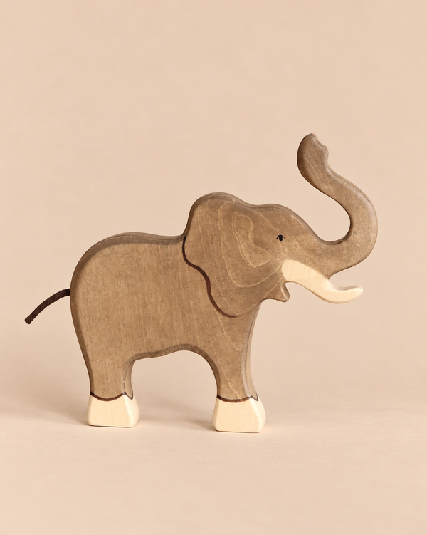 Handcrafted wooden Holztiger Elephant, Trunk Raised figurine with its trunk raised.