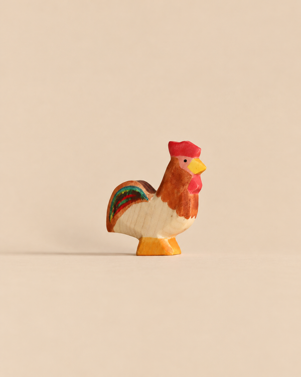 Handmade Holzwald Rooster, a small sustainable wooden figurine with a red comb and colorful tail feathers, perfect for imaginative play.