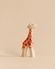 A handmade wooden giraffe toy with painted orange spots from the Handmade Holzwald Safari Animals Set.