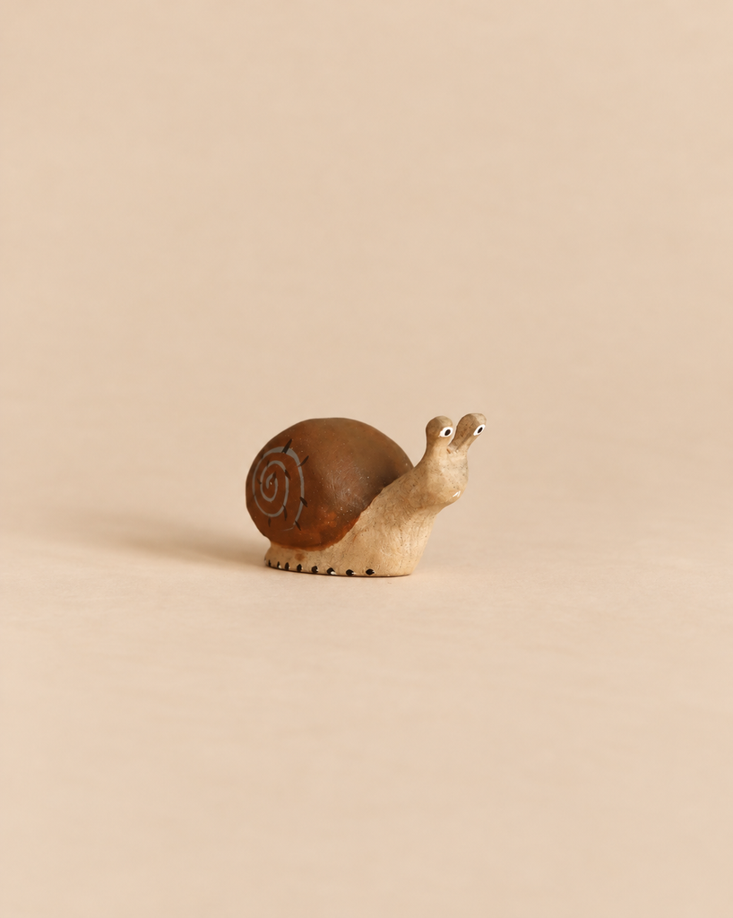 Bumbu Handmade Wooden Snail toy with a brown shell and carved spiral detail.