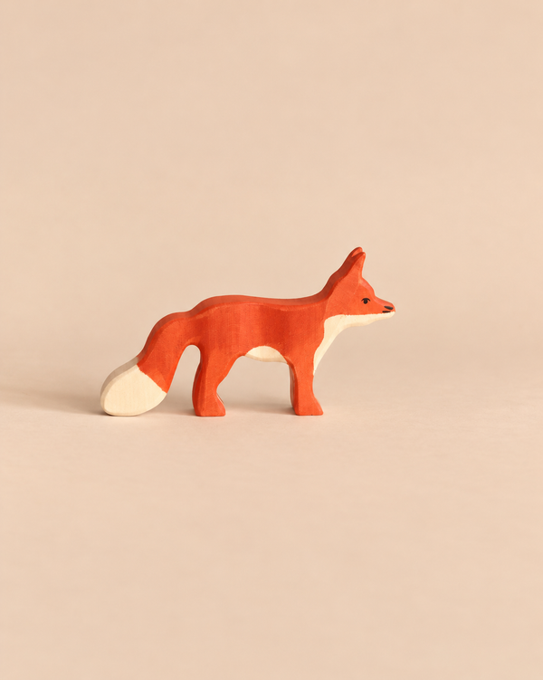 Holztiger Fox, Standing, handcrafted from wood in profile, painted orange with a white chest, muzzle, and tail tip.