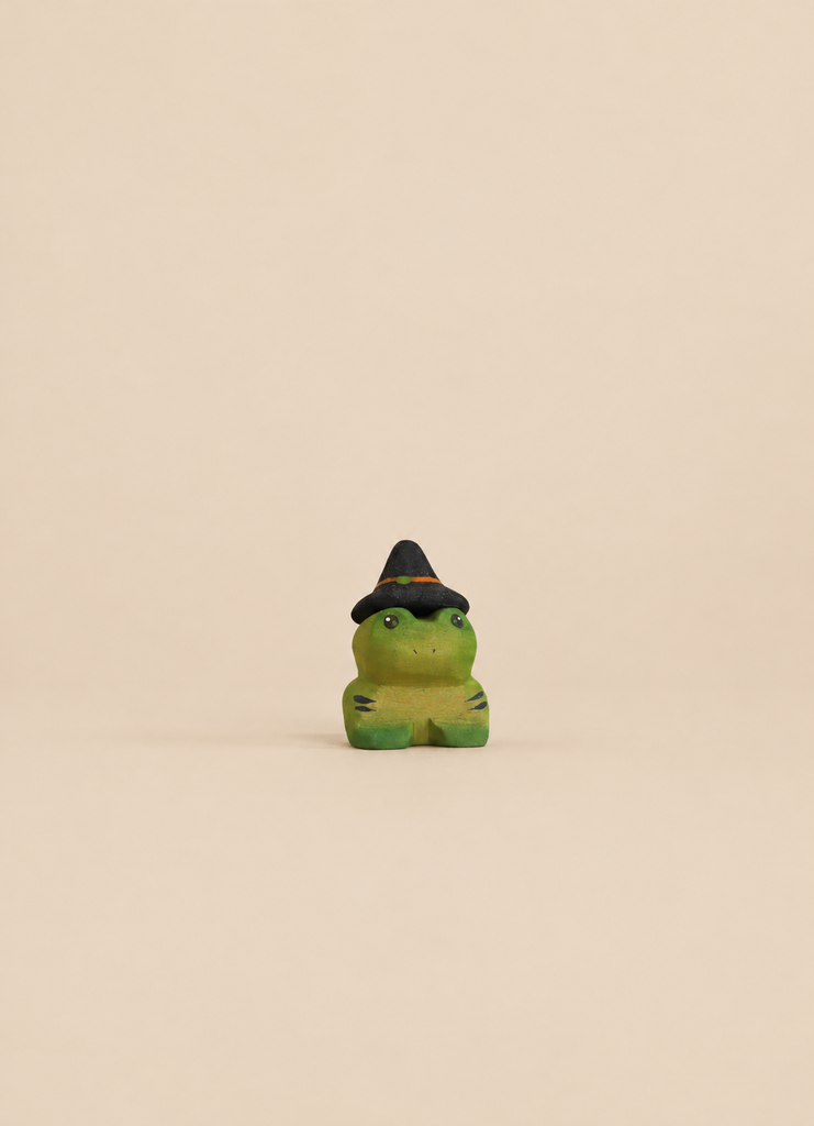 Bumbu Handmade Wooden Spell Frog figurine in small green wood, wearing a black witch hat with an orange band, perfect for imaginative play.
