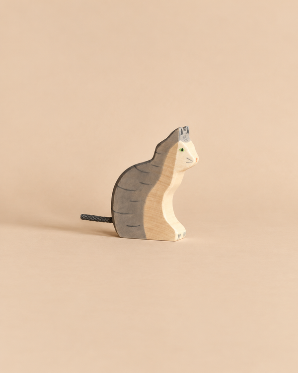 A handcrafted Holztiger Sitting Gray Cat wooden toy figurine of a gray cat sitting.