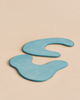 Two blue, irregularly shaped handcrafted wooden Ostheimer Pond Plates - Set of 2 positioned on a plain light background.