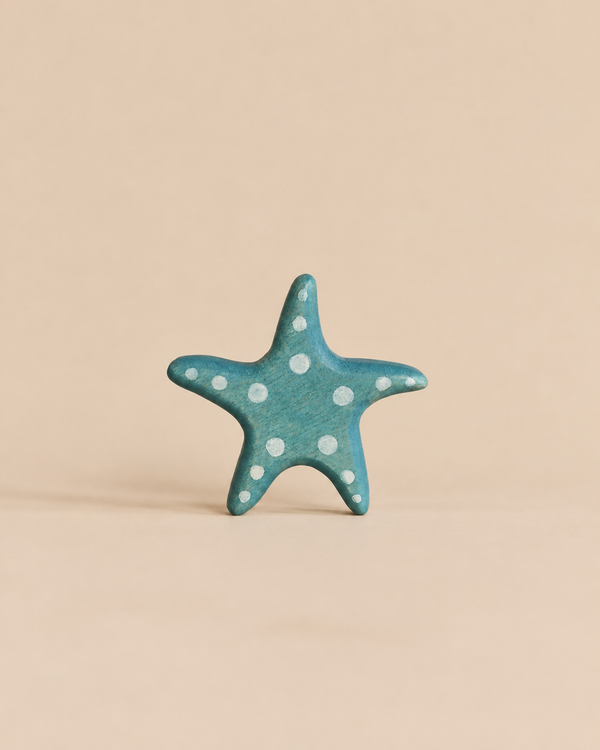 Handmade Holzwald Starfish toy in blue wood with white polka dots.