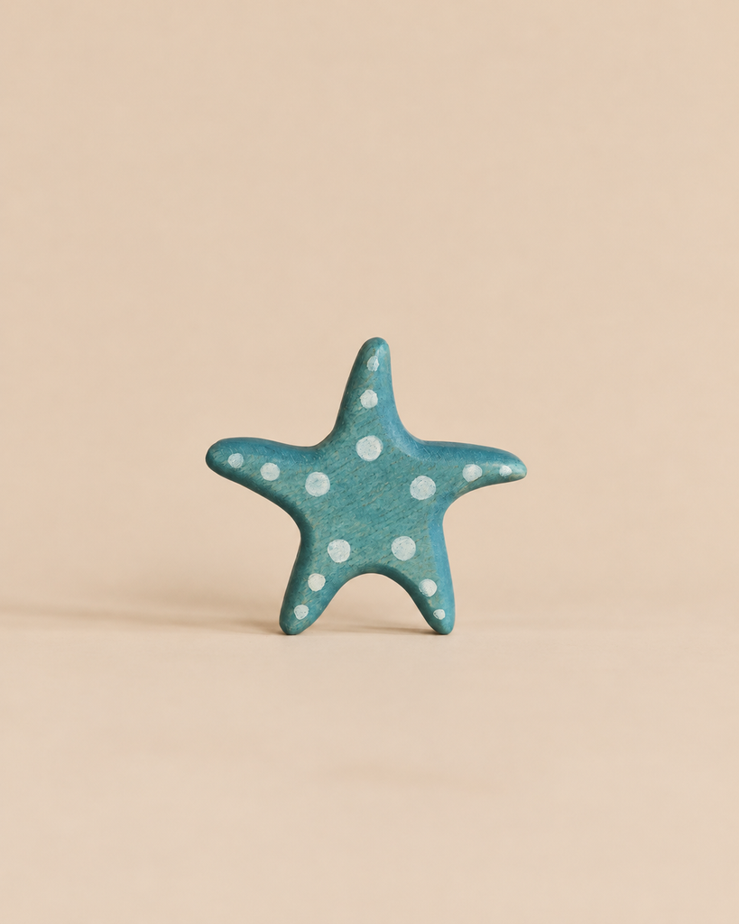 Handmade Holzwald Starfish toy in blue wood with white polka dots.