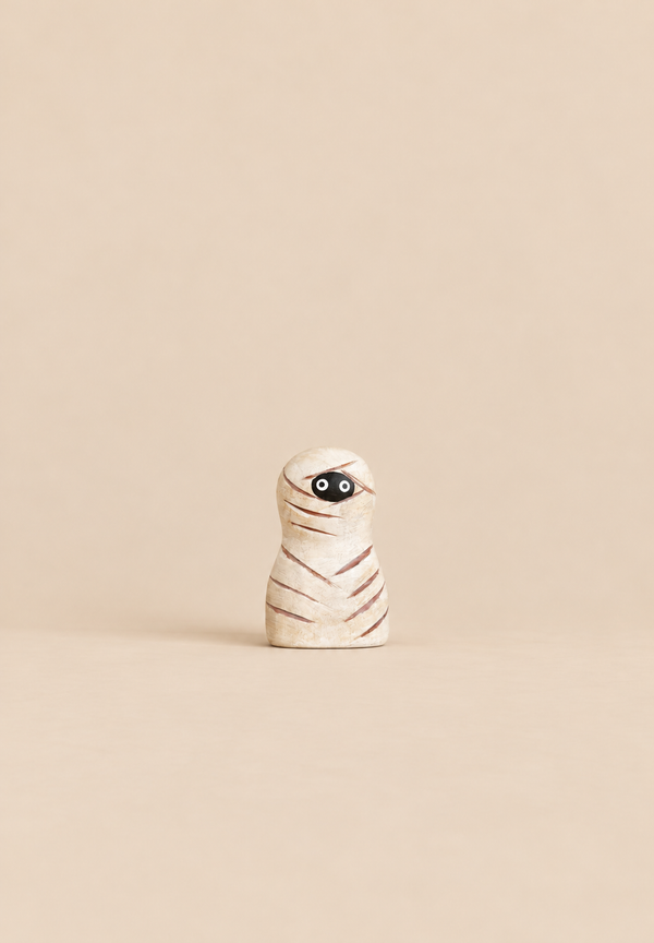 Bumbu Handmade Wooden Enchanted Mummy, a small, wooden Waldorf toy shaped like a mummy wrapped in bandages with large, wide-set eyes.