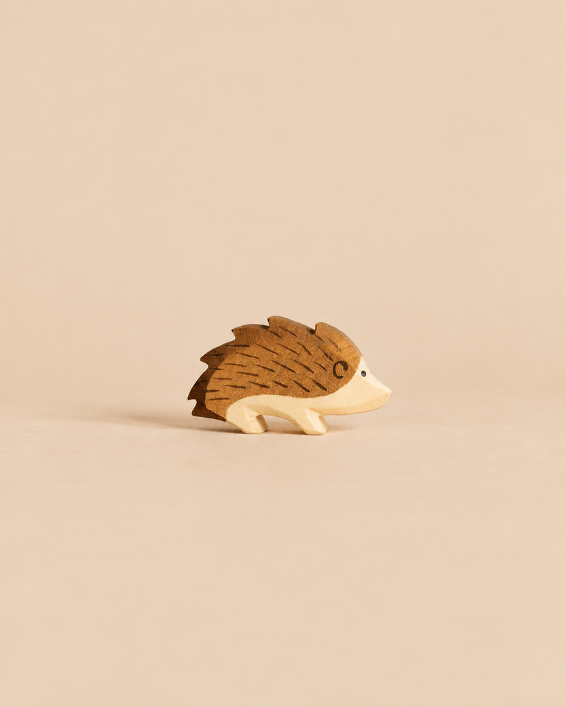 An Ostheimer Hedgehog handcrafted from wood, featuring brown painted quills and a light wood face, perfect for imaginative play.