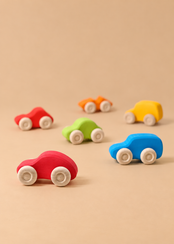 Five small Grimm’s Colored Wooden Cars in various colors arranged on a tan surface.