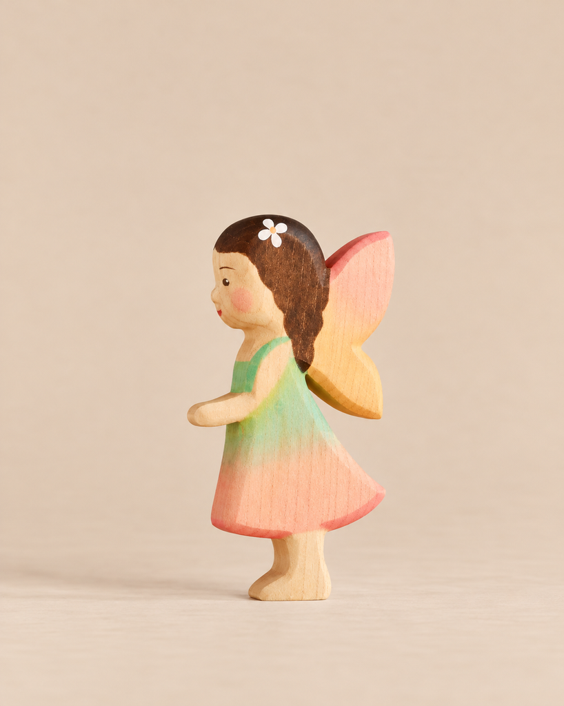 Handmade Holzwald Maya Fairy wooden toy wearing a green and pink dress, featuring brown hair with a white flower accessory and pink wings.