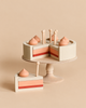 Sabo Concept Handmade Strawberry Layer Cake On A Stand on a pedestal, with one slice removed and a matching slice sitting in front.