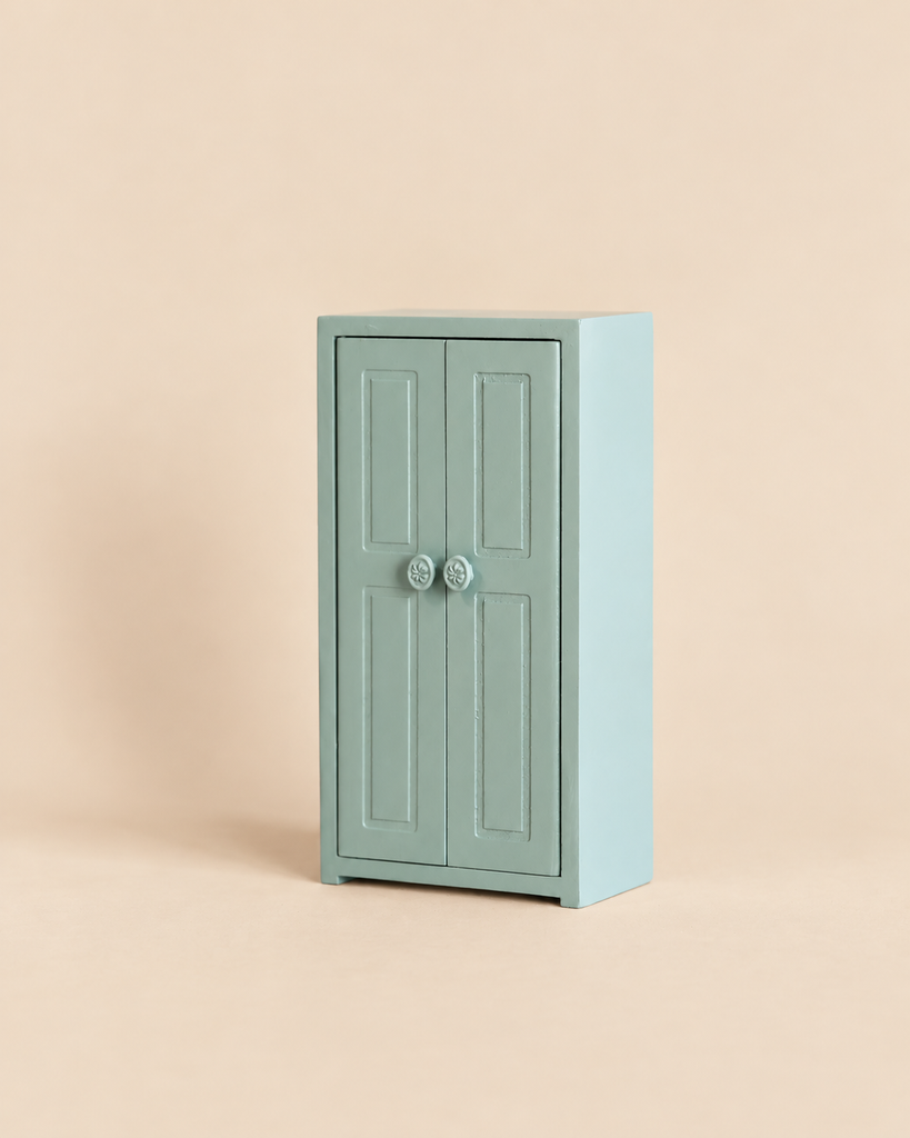 Maileg Mouse Closet - Soft Blue: a small, light blue wooden toy wardrobe with two cabinet doors and decorative round knobs.