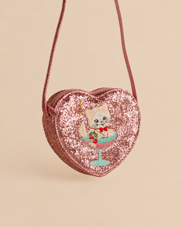 Konges Sloejd Tut Kitty Shoulder Bag, a pink heart-shaped glitter bag featuring an embroidered kitten sitting inside a cocktail glass.