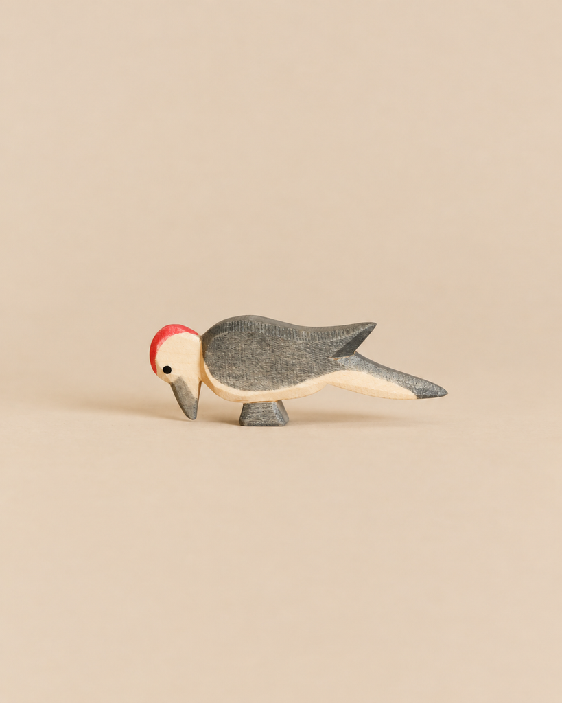 Handcrafted Ostheimer Woodpecker toy with a red crest, grey body, and light underside, perfect for imaginative play.