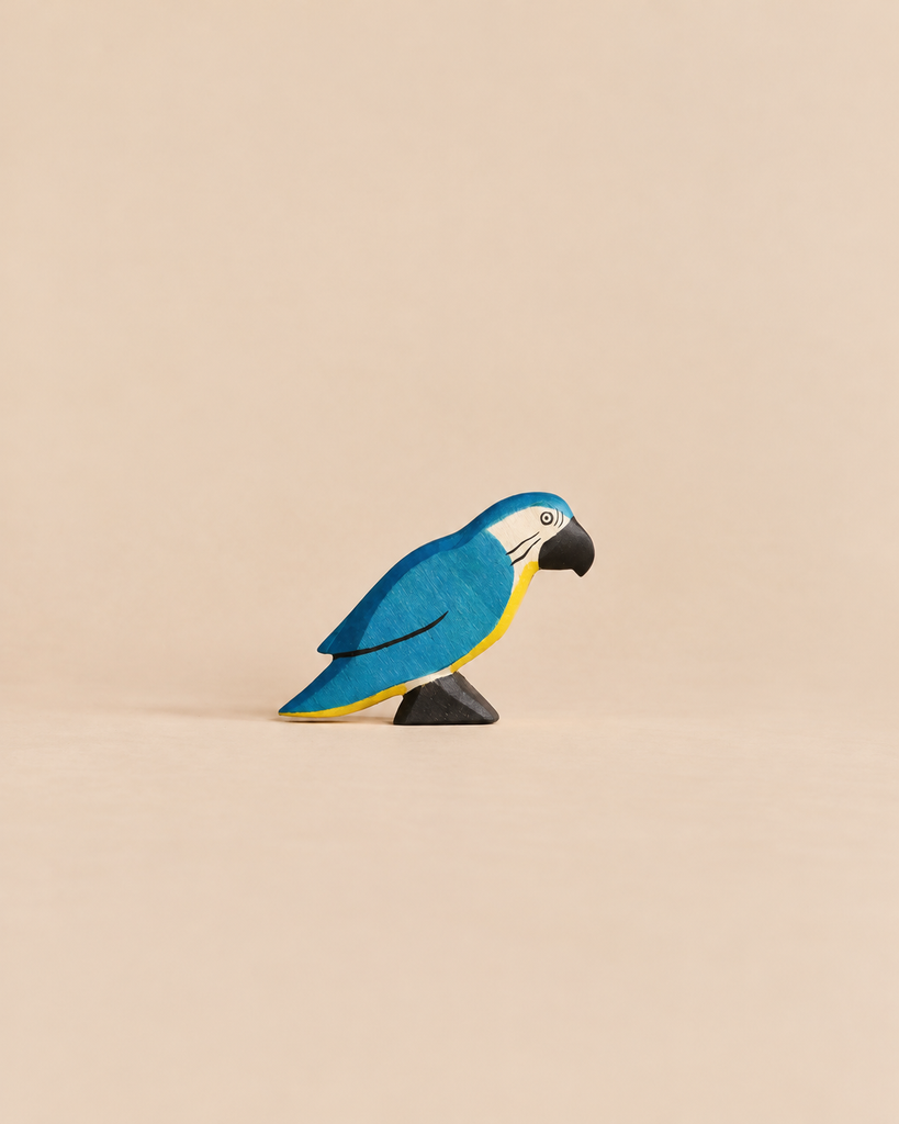 Handmade Holzwald Bird - Blue Parrot, a small wooden figurine of a blue and yellow parrot with a black beak, perfect for sustainable imaginative play.