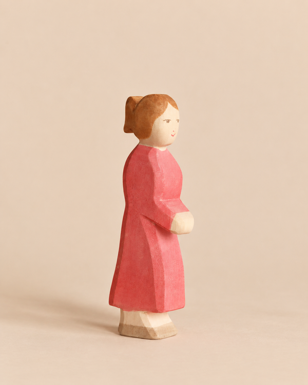 Ostheimer Mother, Red Dress: a handcrafted wooden figure of a woman with brown hair wearing a red dress.