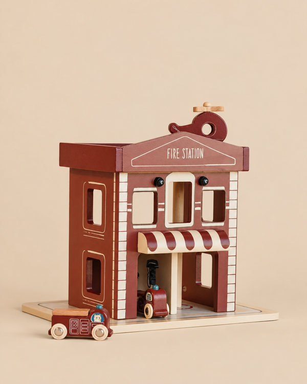 Konges Sloejd - Wooden Fire Station playset with a helicopter landing pad on the roof and a small toy fire truck in front.