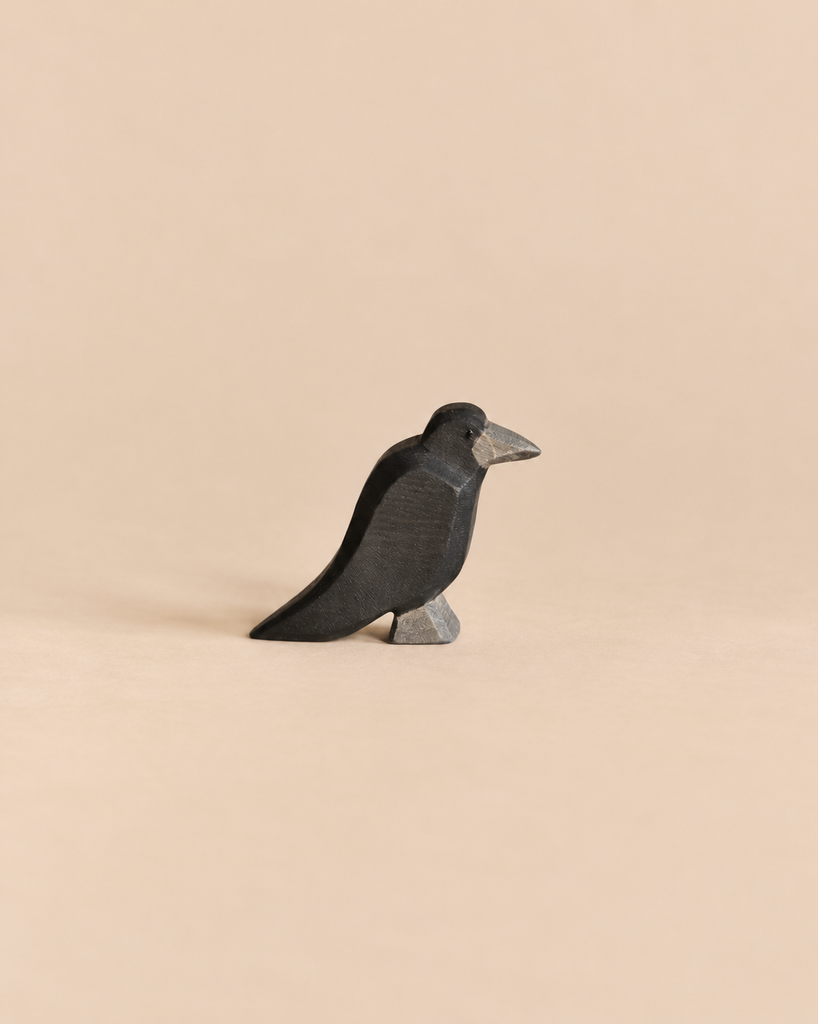 Handcrafted Ostheimer Bird - Raven wooden figurine shown in profile.