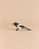 An Ostheimer Bird - Magpie, a handcrafted wooden figurine with black and white markings, perfect for imaginative play.