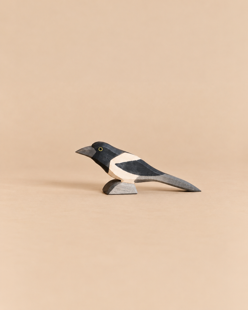 An Ostheimer Bird - Magpie, a handcrafted wooden figurine with black and white markings, perfect for imaginative play.