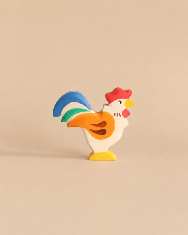 A Holztiger Rooster handcrafted wooden toy painted with a red comb, yellow beak and feet, and a blue, green, and orange tail.