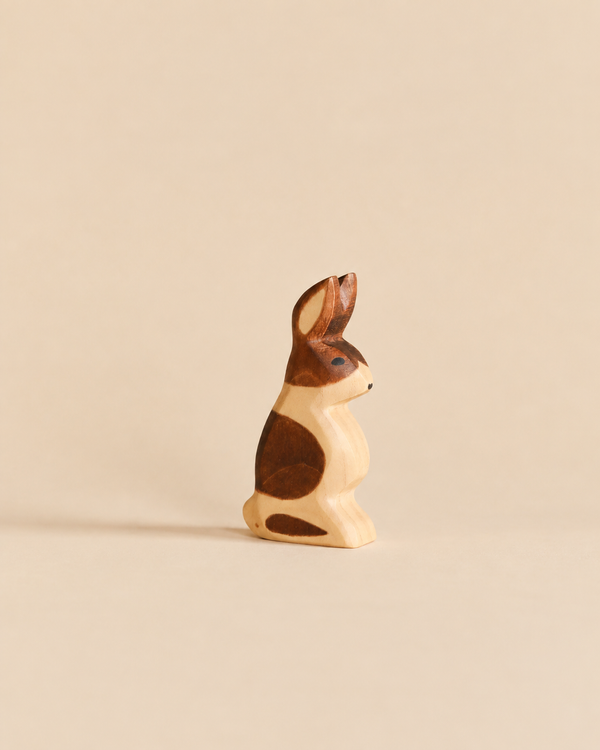 Handmade Holzwald Rabbit - Standing, Spotted, a small wooden rabbit figurine in a standing pose with brown and cream patches, crafted as an educational toy.