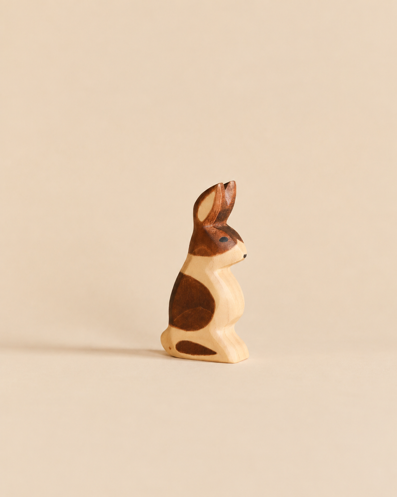 Handmade Holzwald Rabbit - Standing, Spotted, a small wooden rabbit figurine in a standing pose with brown and cream patches, crafted as an educational toy.
