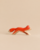 Handmade Holzwald Running Fox, a hand-carved wooden toy of a fox in a running pose, painted in orange and white.
