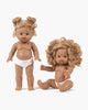 Two Minikane dolls with curly hair and brown skin. Minikane Standing Doll (14") - Louisa stands with buns, wearing a white diaper. The second doll sits with loose curls, holding an object. Both are anatomically correct, neutral in expression, against a plain background.