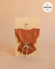Mrs. Ertha Doll Clothes - 13″-14″ - Rusted Comfy Set, featuring a rust-colored handmade short-sleeve top and drawstring shorts, perfectly sized for Minikane dolls, is displayed on a wooden hanger against a beige background. Text in the corner reads “fits MINIKANE 13”.“.