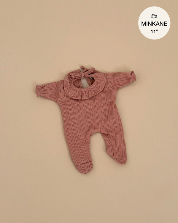 The Minikane 11" Doll Clothing | Camille Onesie in Dotted Cotton - Brown Sugar is a long-sleeve romper with ruffled collar and back tie, shown flat on beige. A label reads "fits MINIKANE 11". Perfect for Minikane dolls.
