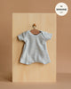 The Minikane 11" Doll Clothing | Shorty Bodysuit in Ribbed Cotton - Heather Blue is a stylish, short-sleeved, light blue ribbed knit bodysuit for Minikane Babies—perfect doll clothes for playtime.