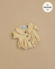 A light yellow Leonore Ruffled Romper in vanilla cotton gauze, featuring a Peter Pan collar, ruffled hem, and three brown buttons—perfectly sized for Minikane Gordis dolls. Text reads: “fits MINIKANE 13''.”.