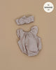 The Minikane 13" Doll Clothing | Clara Romper & Headband in Washed Linen - Nude features ruffled sleeves and a knotted headband, displayed on a beige background with a label reading "fits Minikane Gordis dolls 13".