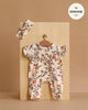 The Minikane 11" Doll Clothing | Lili Jumpsuit & Headband in Jersey - Gisele features a soft floral-print romper with short sleeves and front buttons, displayed on a mini hanger. Tag reads "fits MINIKANE 11". Made in France.