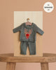 The Minikane 13" Doll Clothing | Christmas Reindeer Two-Piece Knit Set - Green is displayed on a hanger against a wooden board and beige background. This festive outfit fits 13 inch dolls like Minikane.