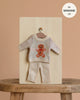 The Minikane 13" Doll Clothing | Christmas Gingerbread Two-Piece Knit Set features a cream knit sweater with a gingerbread man and matching pants—perfect clothes and accessories for 13 inch Minikane dolls.
