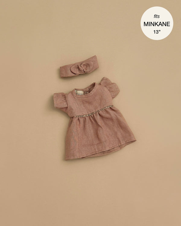 The Minikane Doll Clothing Daisy Dress & Headband in Washed Linen - Hazelnut, designed for 13-inch Minikane dolls, features puff sleeves and a gathered waist and is displayed on a neutral beige background.