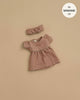 The Minikane Doll Clothing Daisy Dress & Headband in Washed Linen - Hazelnut, designed for 13-inch Minikane dolls, features puff sleeves and a gathered waist and is displayed on a neutral beige background.