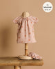 A small mannequin displays the Minikane Doll Clothing set, featuring the Sabrina Nightgown with pink heart patterns and a matching ribbed knit headband. Designed for 13" to 14" Minikane dolls, it showcases French craftsmanship and is hand washable against a soft beige background.