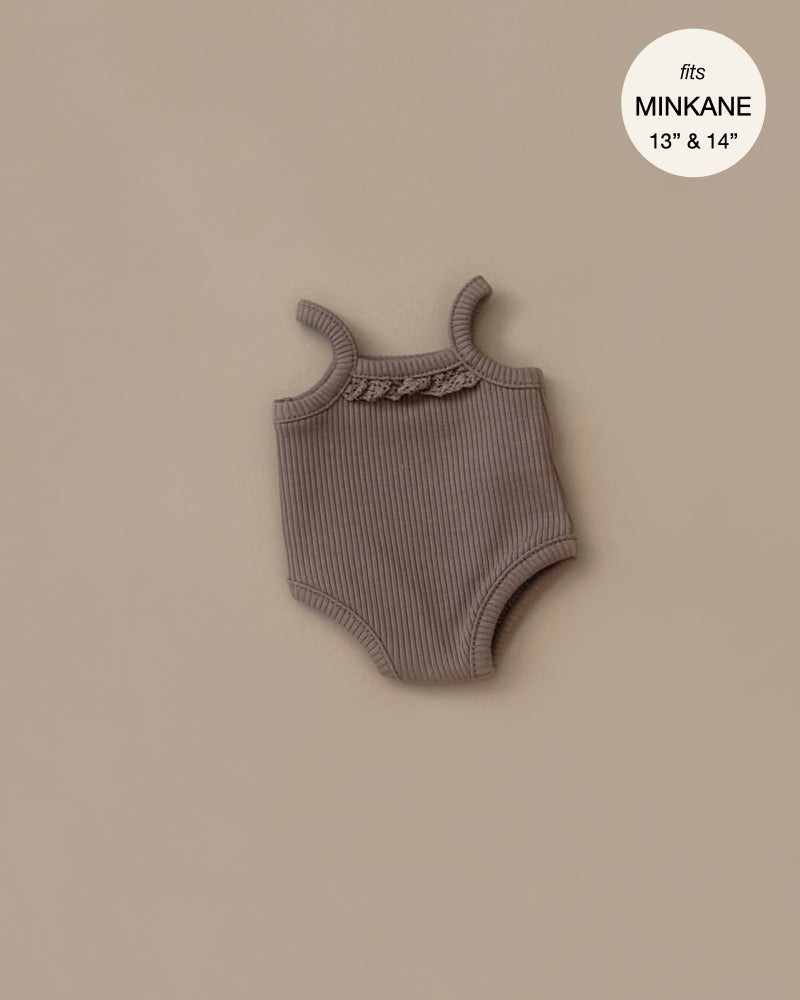 The Les P'tits Basiques Cocoa Ribbed Bodysuit by Minikane is a charming taupe onesie with ruffled neckline, designed for 13" and 14" Gordis dolls. Hand washable and set against a plain beige background, it's perfect for doll enthusiasts.