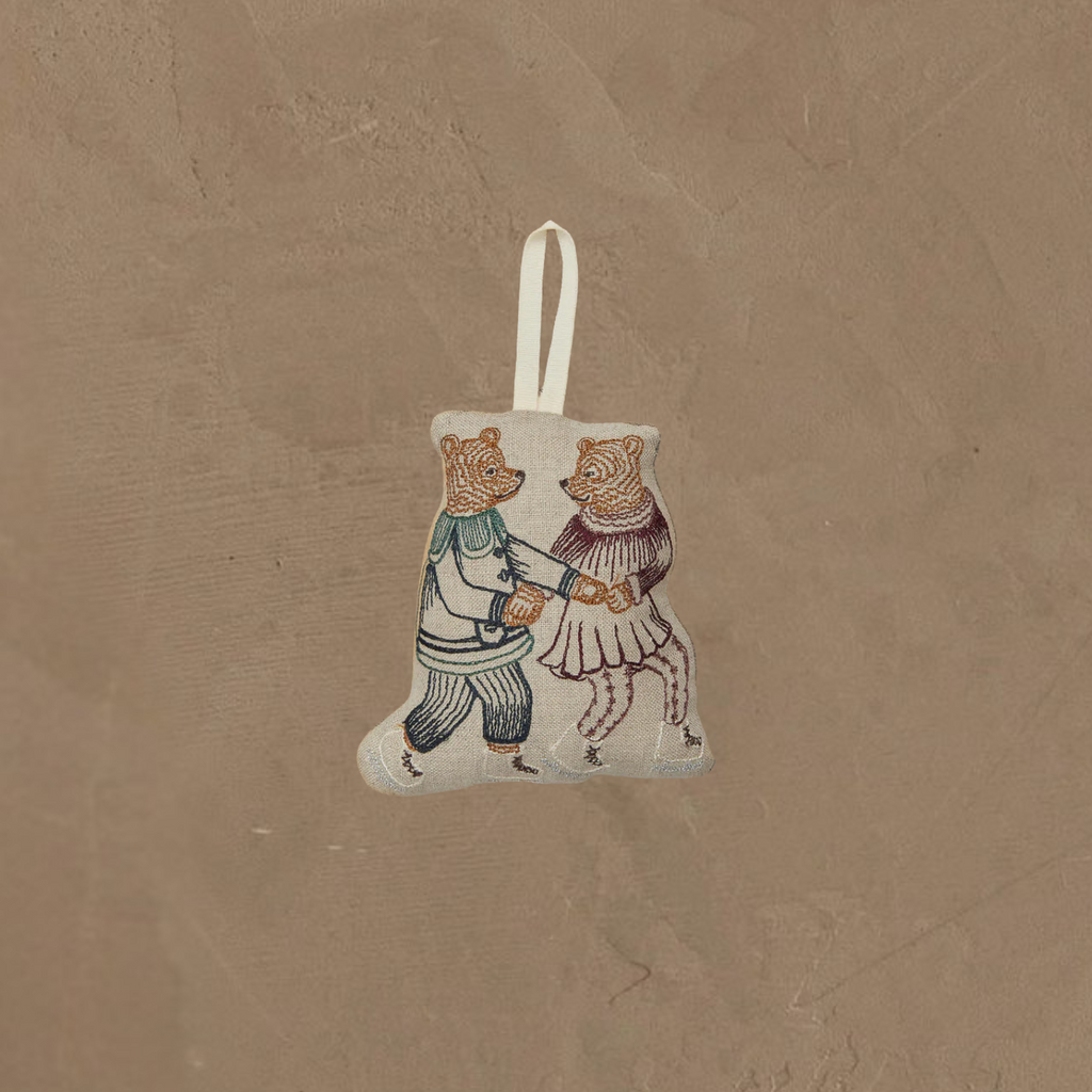 The Coral & Tusk Ice Skater Bears Ornament features two embroidered bears—one in blue pants and shirt, the other in a red skirt and top—holding hands as they skate. A white loop makes it easy to hang. Perfect as an adorable anniversary gift.