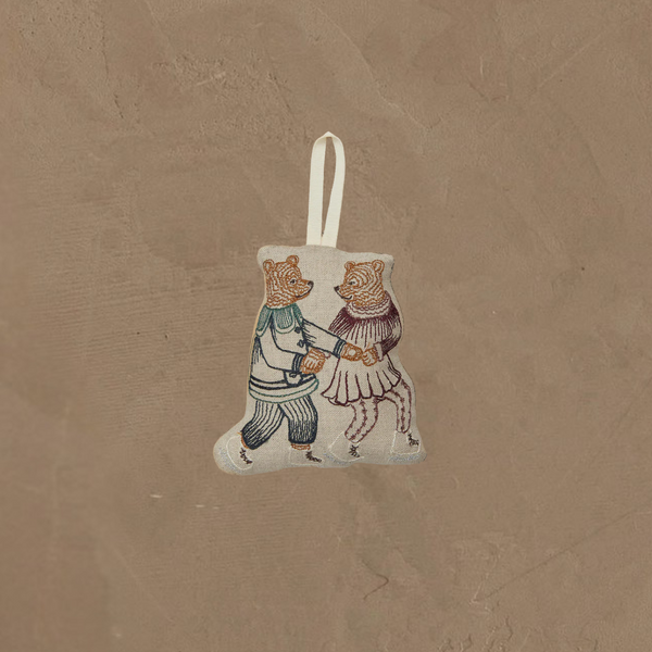 The Coral & Tusk Ice Skater Bears Ornament features two embroidered bears—one in blue pants and shirt, the other in a red skirt and top—holding hands as they skate. A white loop makes it easy to hang. Perfect as an adorable anniversary gift.